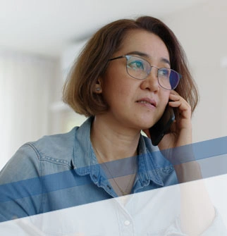 woman on cellphone in front of laptop