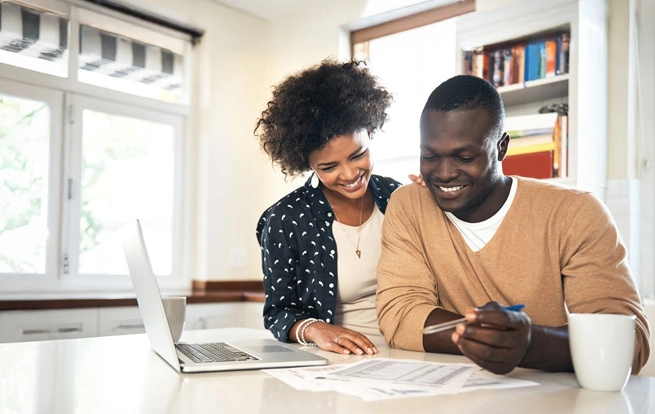 couple laughing laptop kitchen